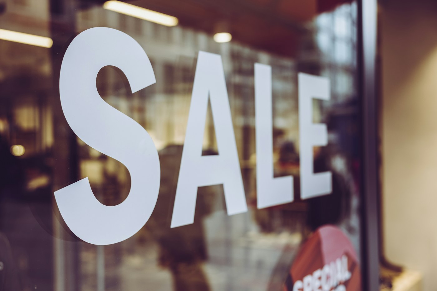 Large SALE sign in a store window, representing Amazon coupons, deals, and Prime Exclusive Discounts